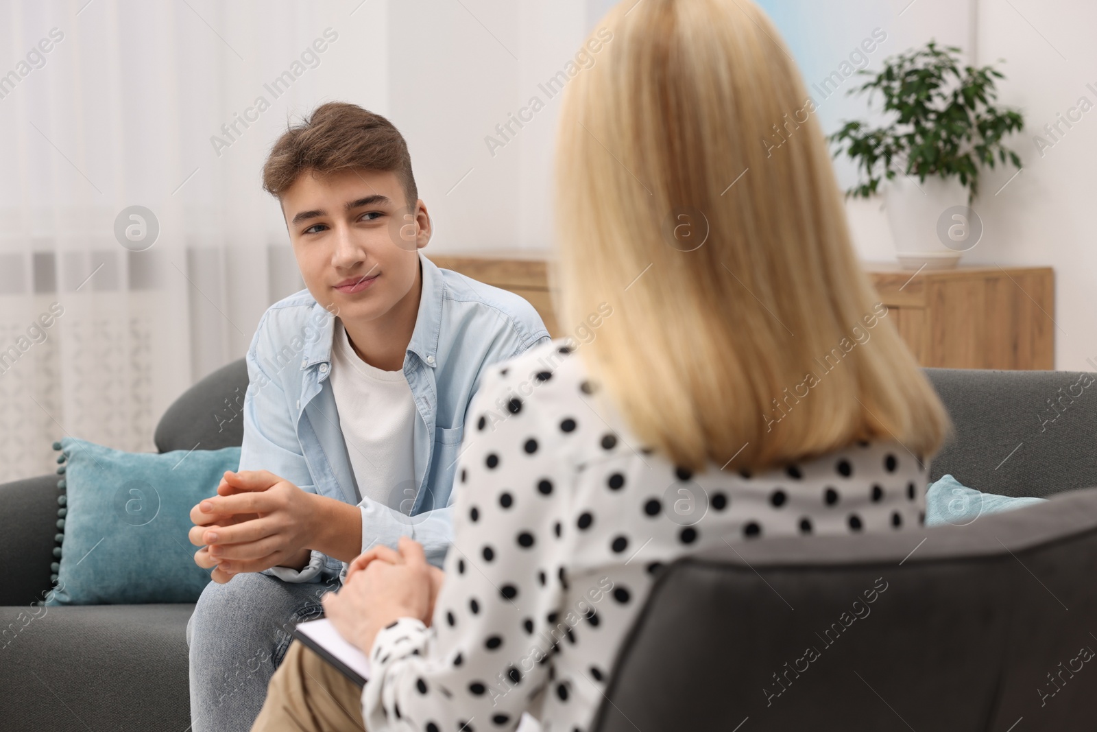 Photo of Psychologist working with teenage boy in office