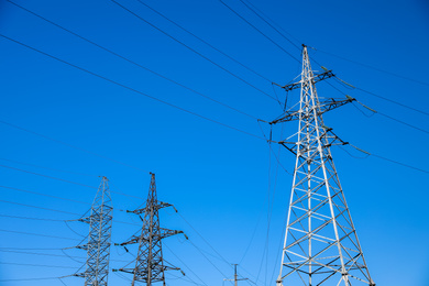 Photo of Modern high voltage towers against blue sky