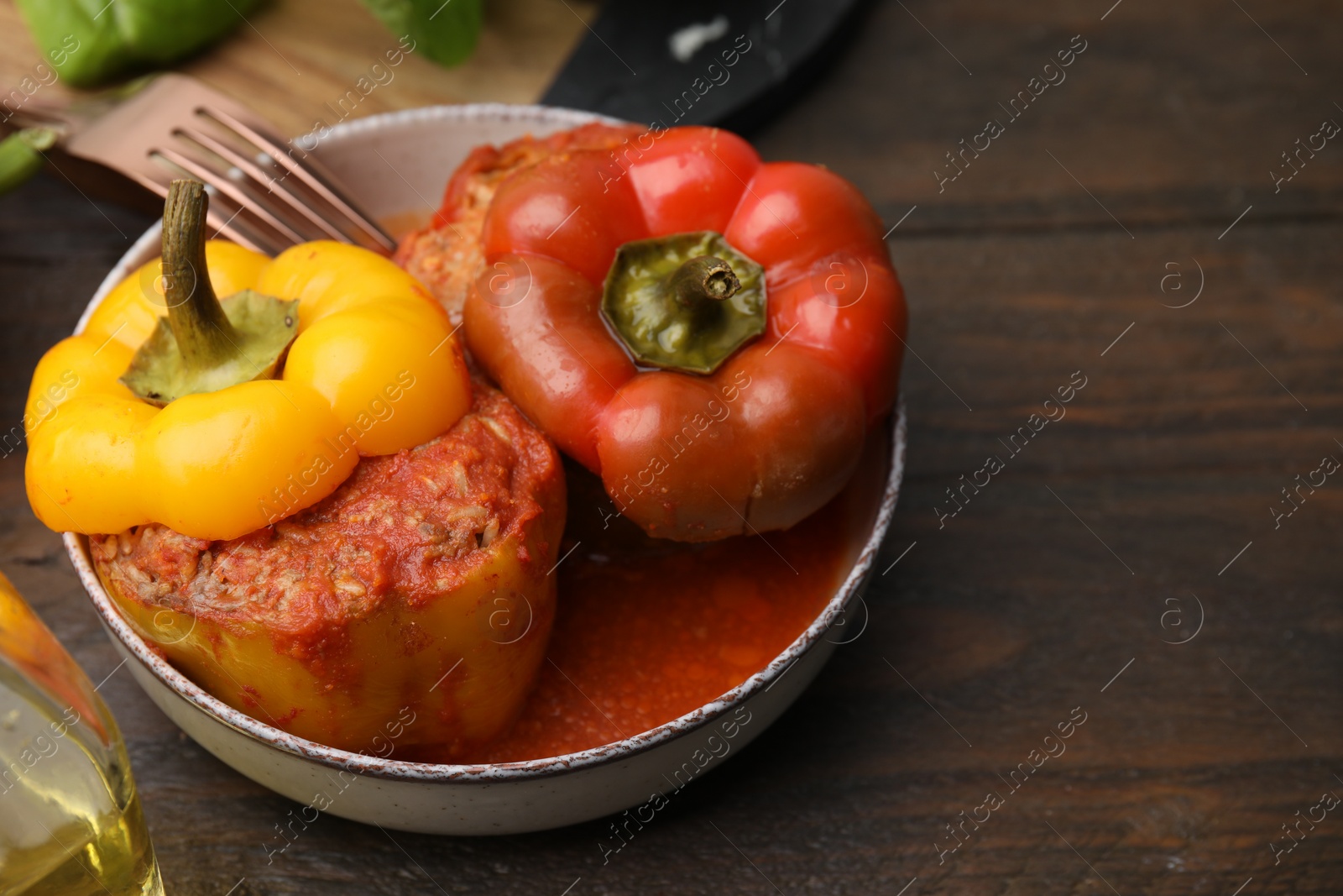 Photo of Delicious stuffed bell peppers served on wooden table. Space for text