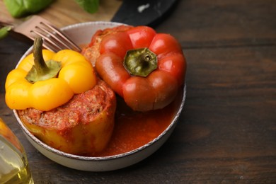 Photo of Delicious stuffed bell peppers served on wooden table. Space for text