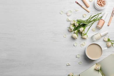 Photo of Flat lay composition with beautiful roses and cosmetics on wooden background. Space for text