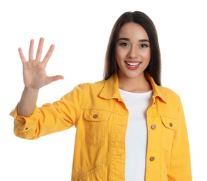 Woman in yellow jacket showing number five with her hand on white background