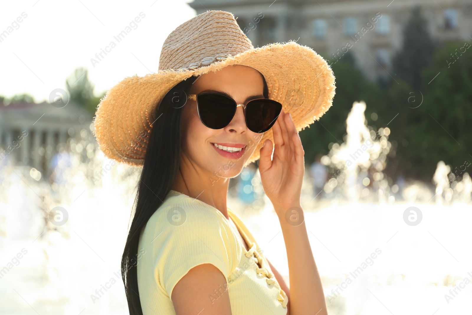 Photo of Beautiful young woman wearing stylish sunglasses outdoors