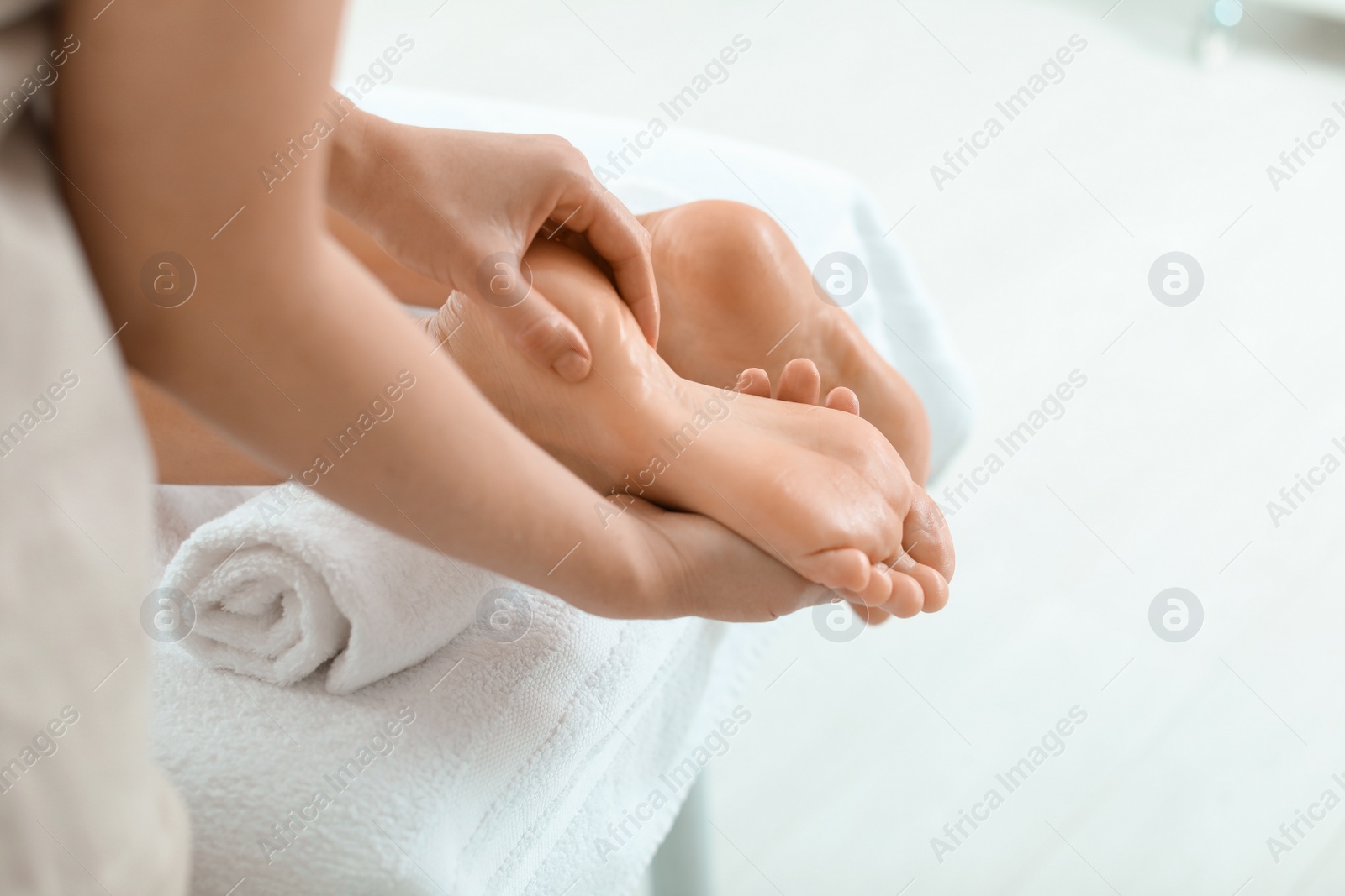 Photo of Woman receiving foot massage in wellness center, closeup