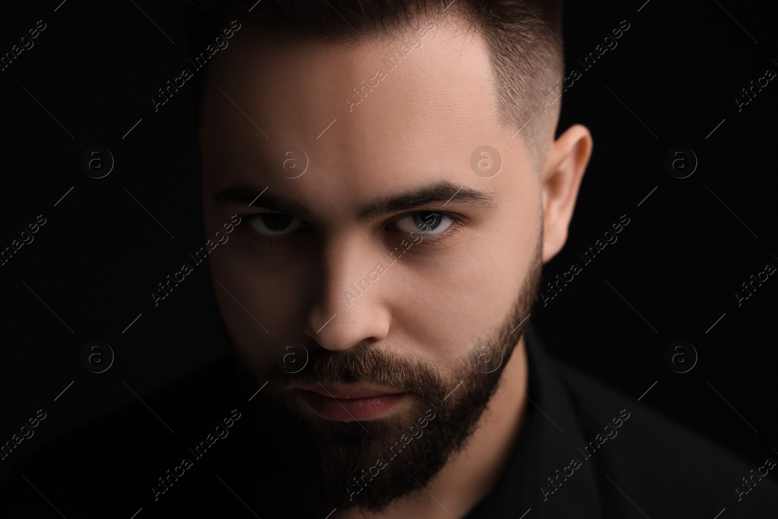 Photo of Evil eye. Man with scary eyes on black background