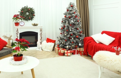 Beautiful living room interior with burning fireplace and Christmas tree