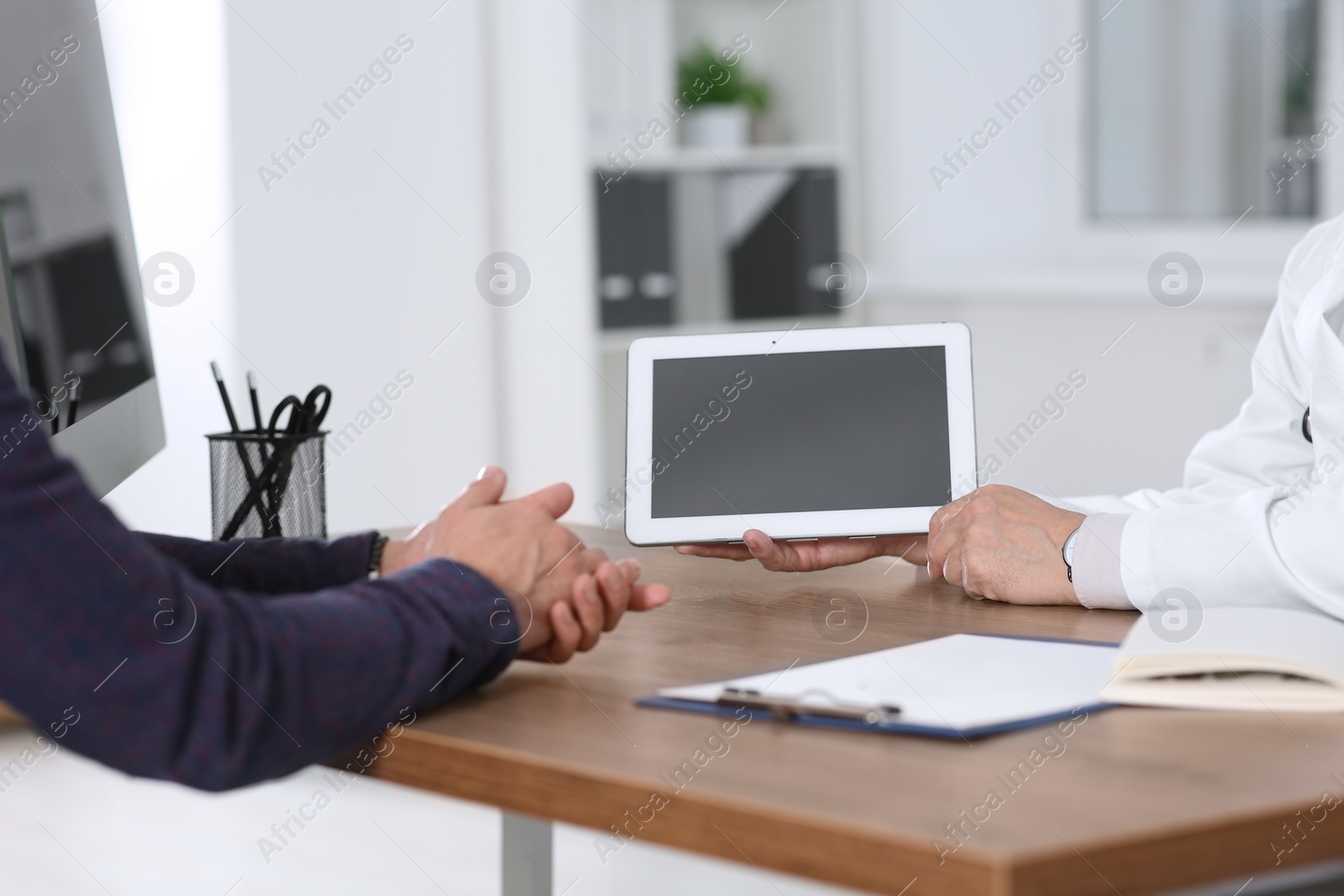 Photo of Patient having appointment with senior doctor in clinic, closeup