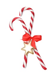 Photo of Tasty candy canes with bow and Christmas decor on white background