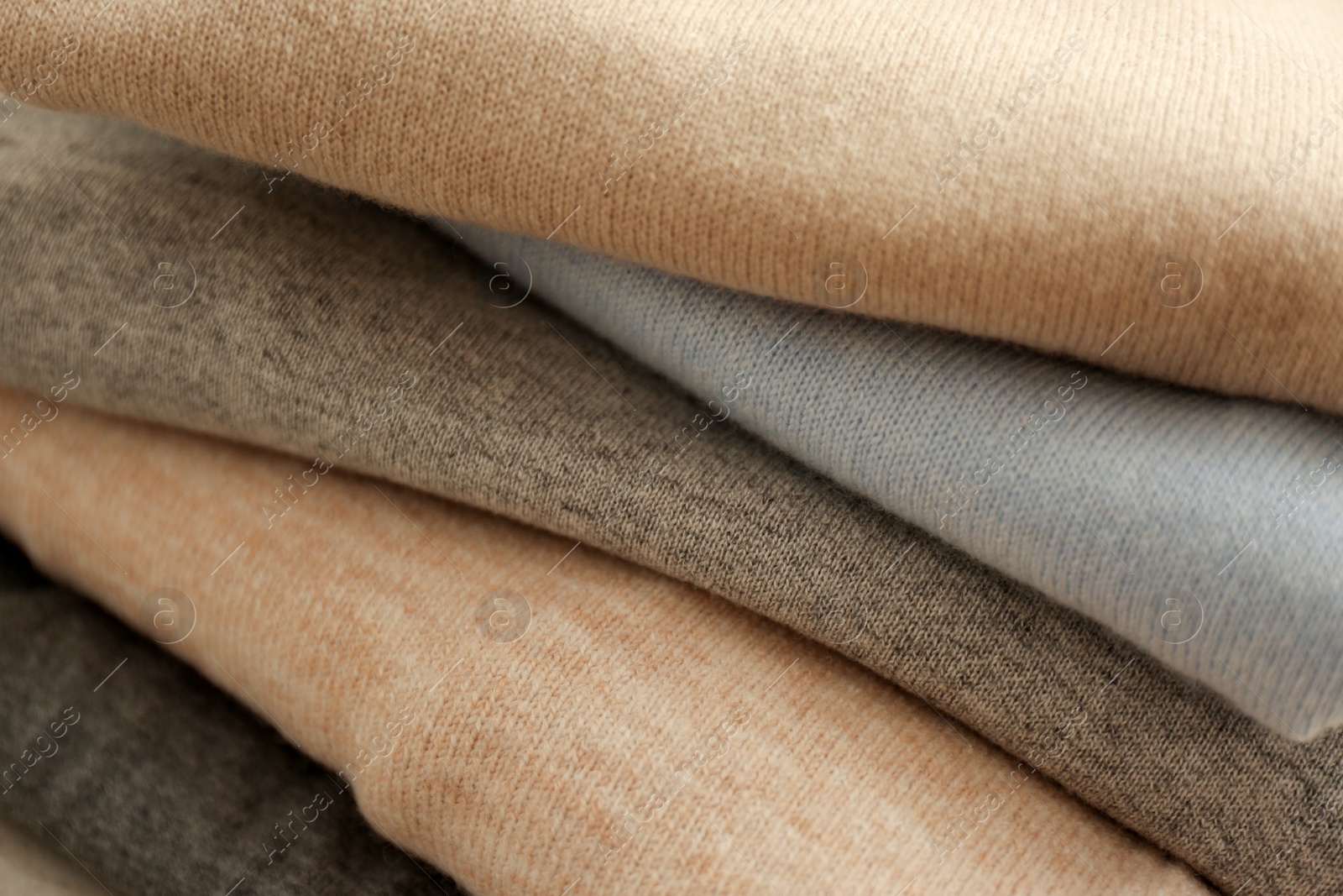 Photo of Stack of cashmere clothes as background, closeup