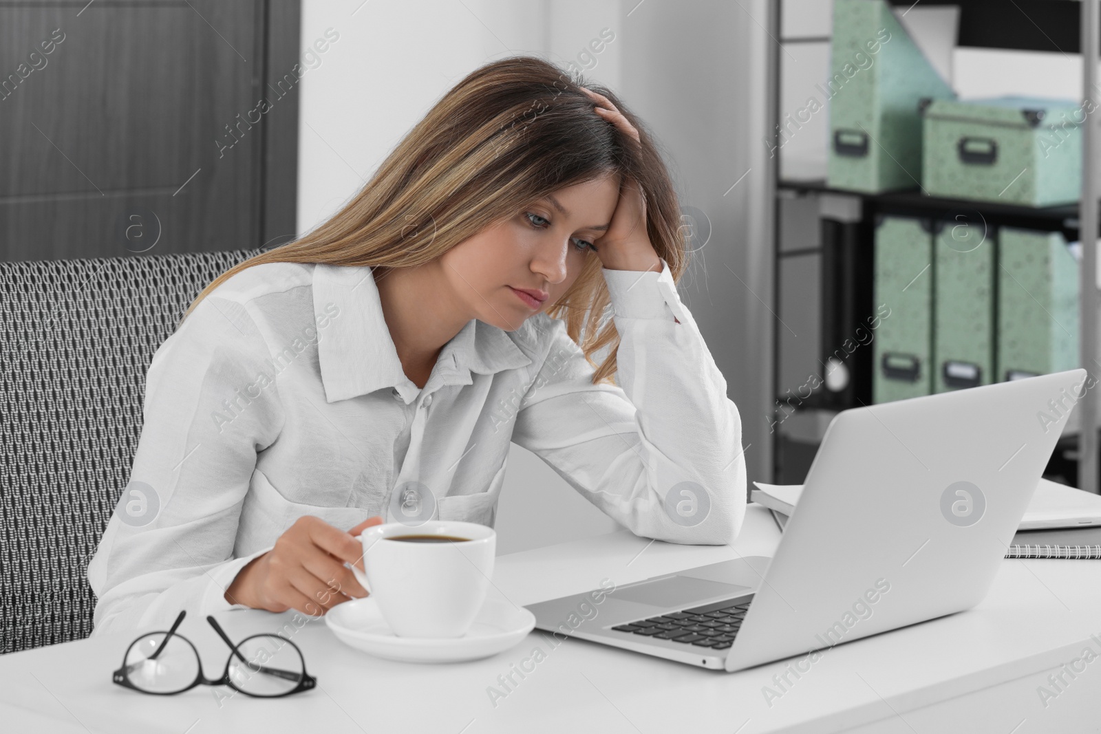 Photo of Sleepy young woman at workplace in office