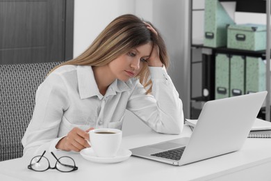 Photo of Sleepy young woman at workplace in office