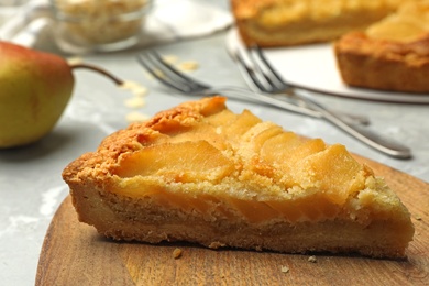 Photo of Piece of delicious sweet pear tart on table, closeup