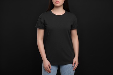 Woman wearing black t-shirt on dark background, closeup