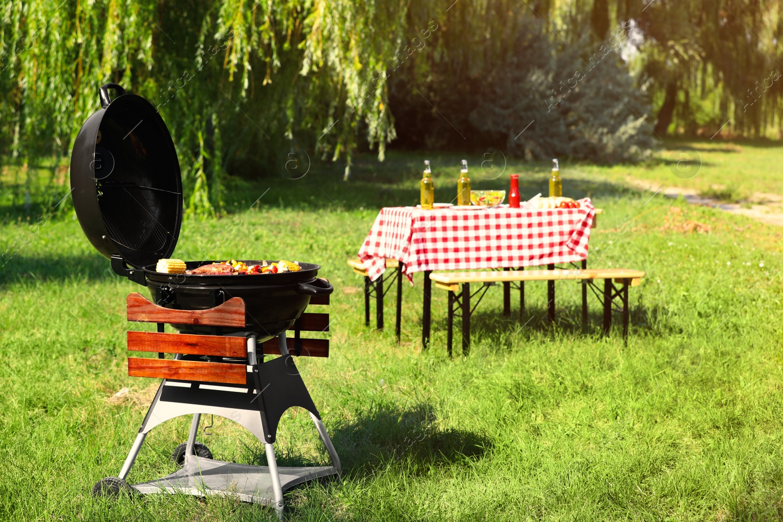 Photo of Modern barbecue grill with tasty food in park