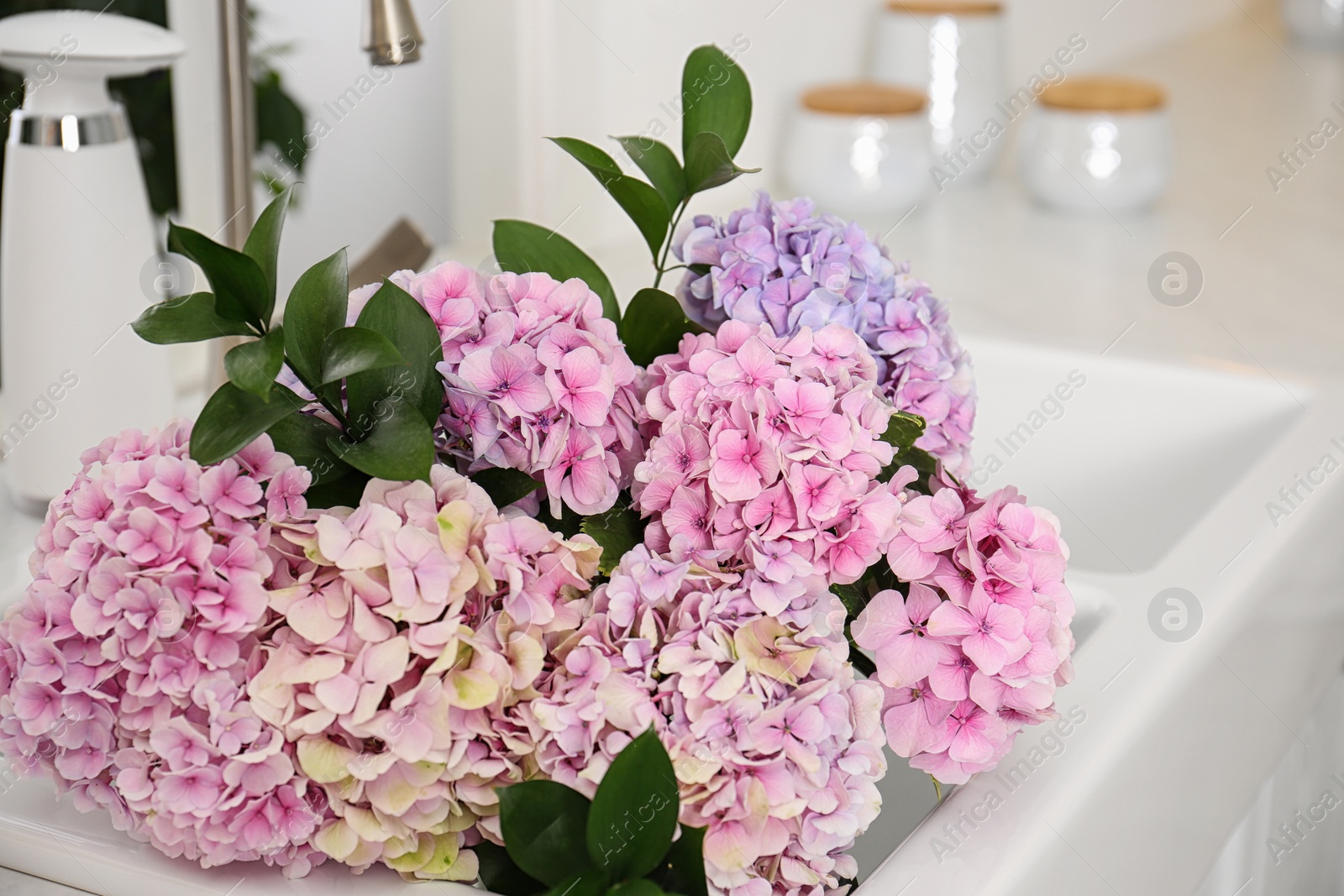 Photo of Bouquet with beautiful hydrangea flowers bouquet in sink, closeup