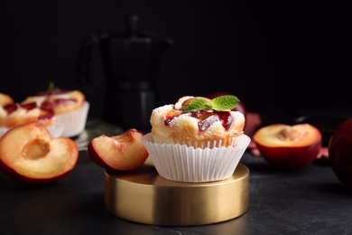 Delicious cupcakes with plums on black table, closeup