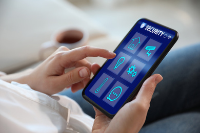 Image of Woman using home security app indoors, closeup