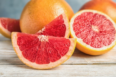 Photo of Composition with yummy grapefruits on wooden table, closeup