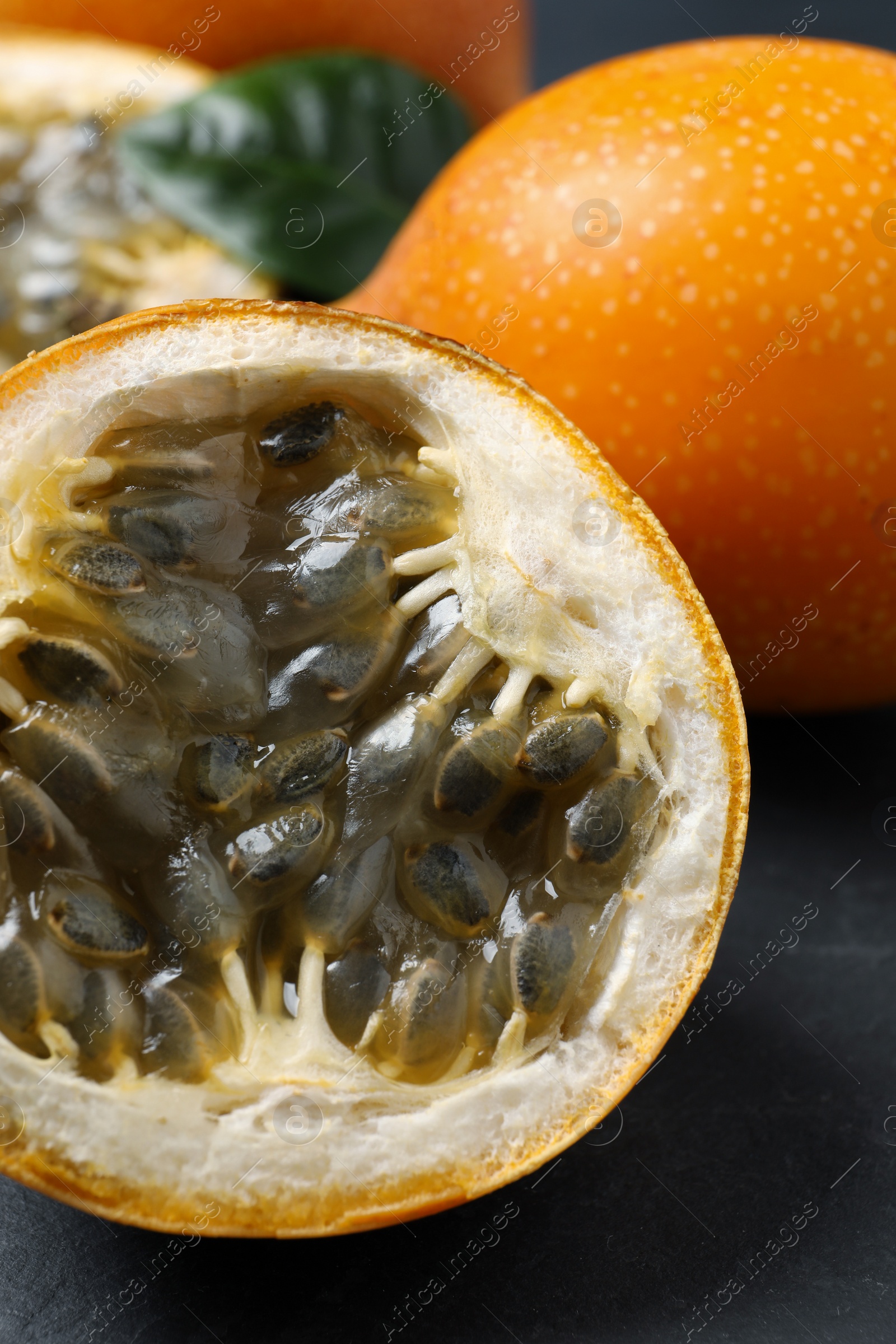 Photo of Delicious ripe granadillas on black table, closeup