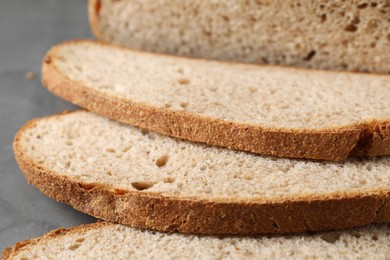 Photo of Freshly baked cut sourdough bread on grey table, closeup