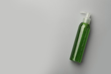 Photo of Bottle of green cosmetic gel on light background, top view. Space for text