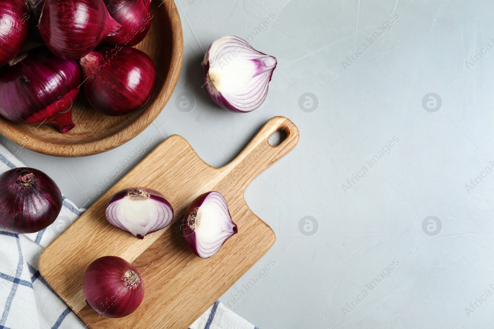 Photo of Flat lay composition of ripe red onions and space for text on grey table