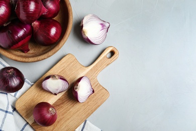 Photo of Flat lay composition of ripe red onions and space for text on grey table