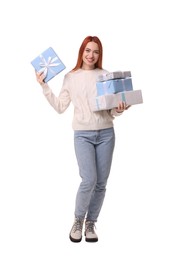 Young woman in sweater with Christmas gifts on white background