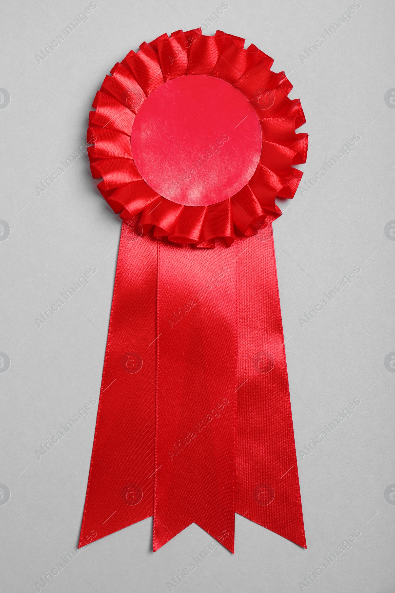 Photo of Red award ribbon on grey background, top view