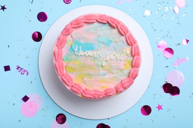 Photo of Cute bento cake with tasty cream and confetti on light blue background, flat lay