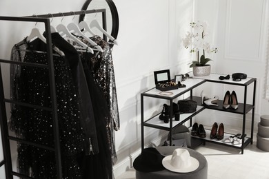 Shelving unit with stylish women's shoes, clothes and accessories in dressing room