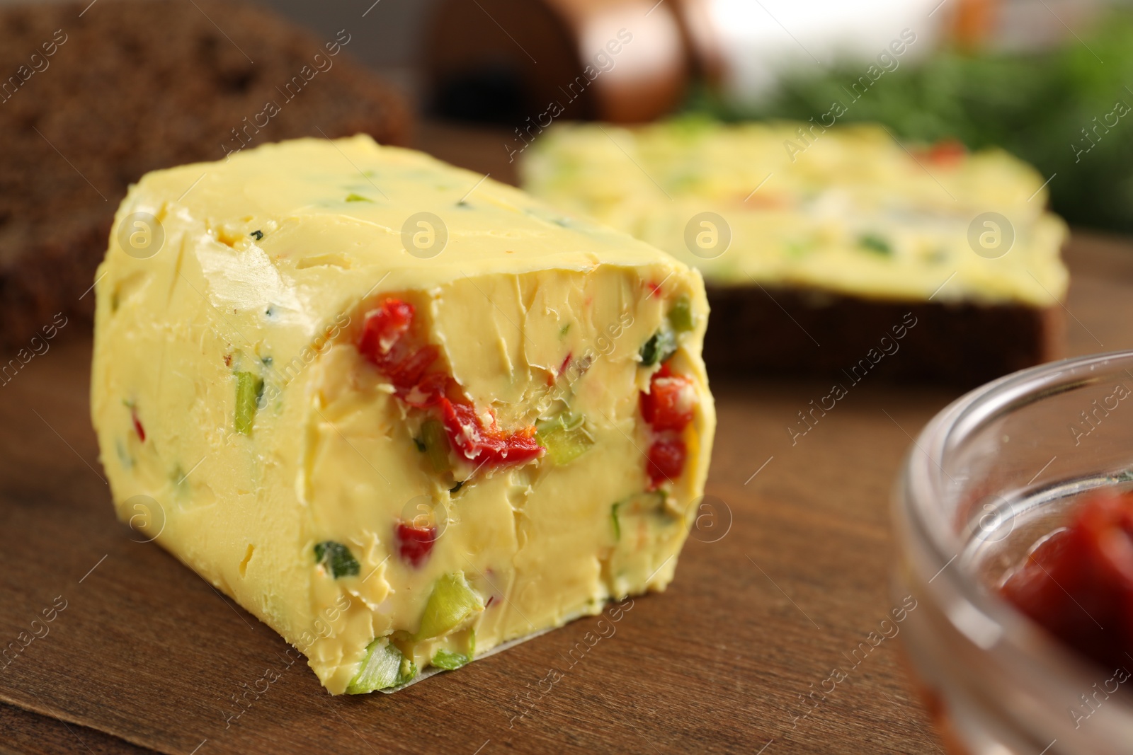 Photo of Tasty butter with green onion and chili pepper on wooden board, closeup