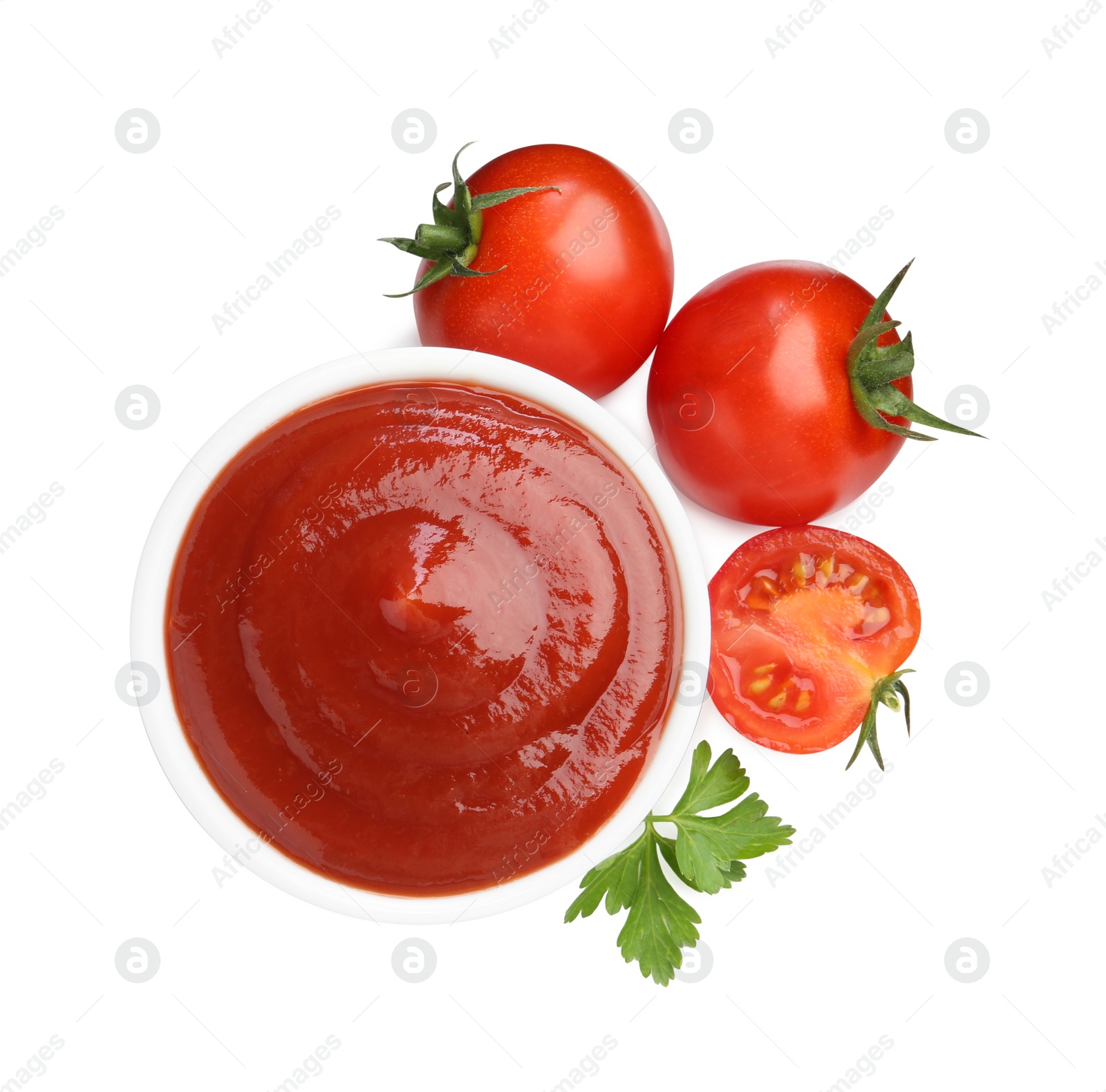 Photo of Tasty ketchup in bowl, parsley and fresh tomatoes isolated on white, top view