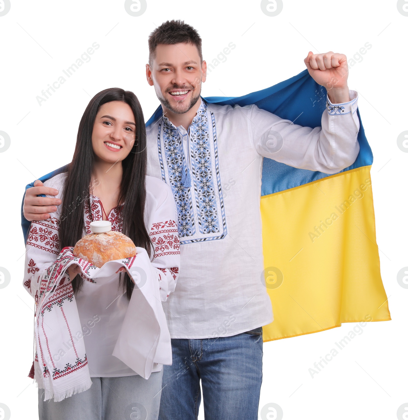 Photo of Happy couple with flag of Ukraine and traditional korovai on white background