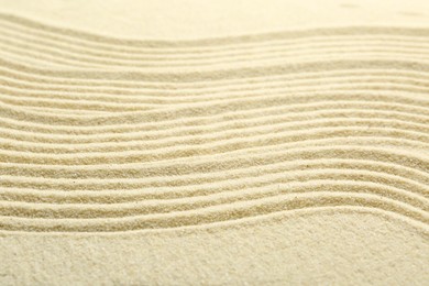 Photo of Zen rock garden. Wave pattern on beige sand