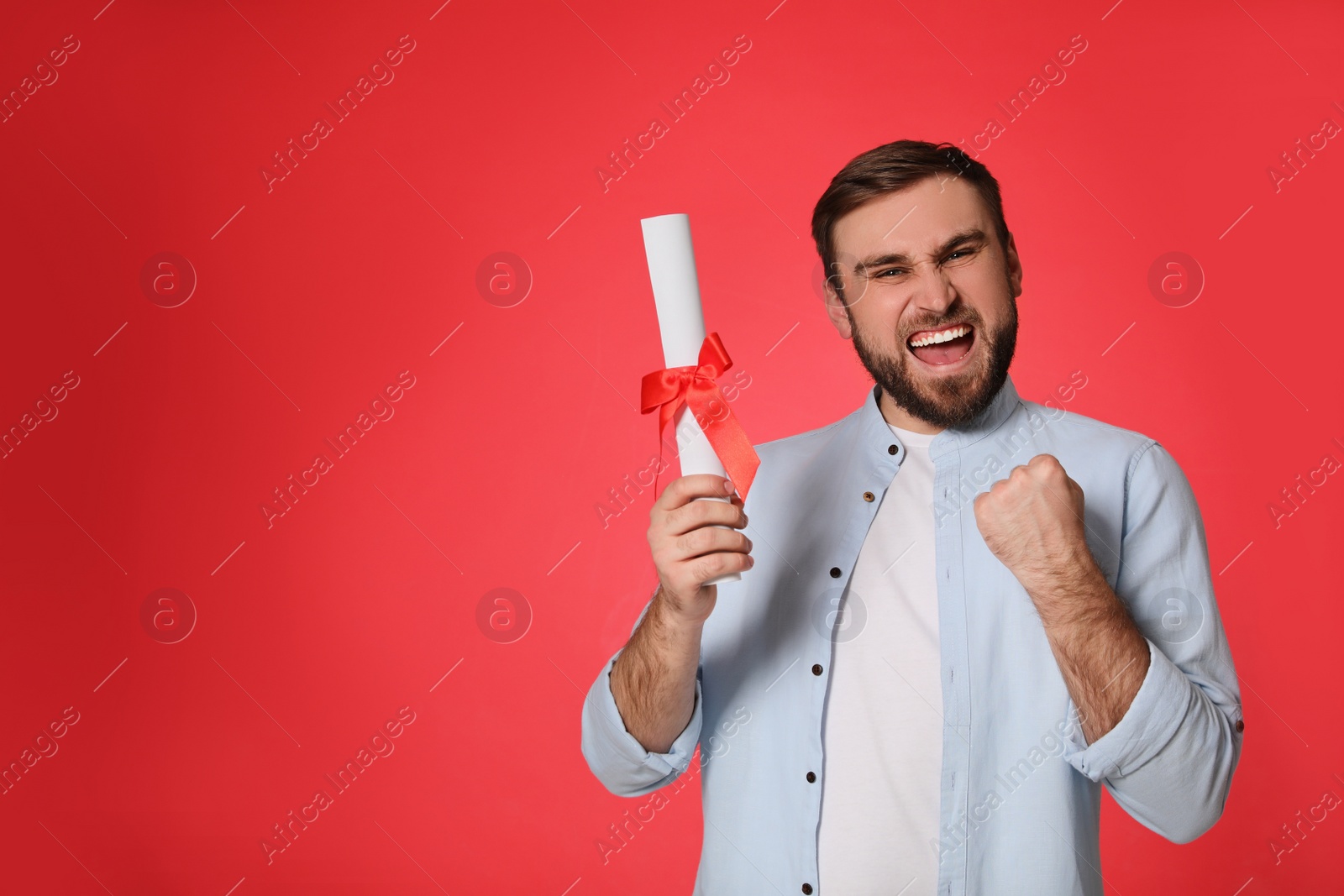 Photo of Emotional student with diploma on red background. Space for text