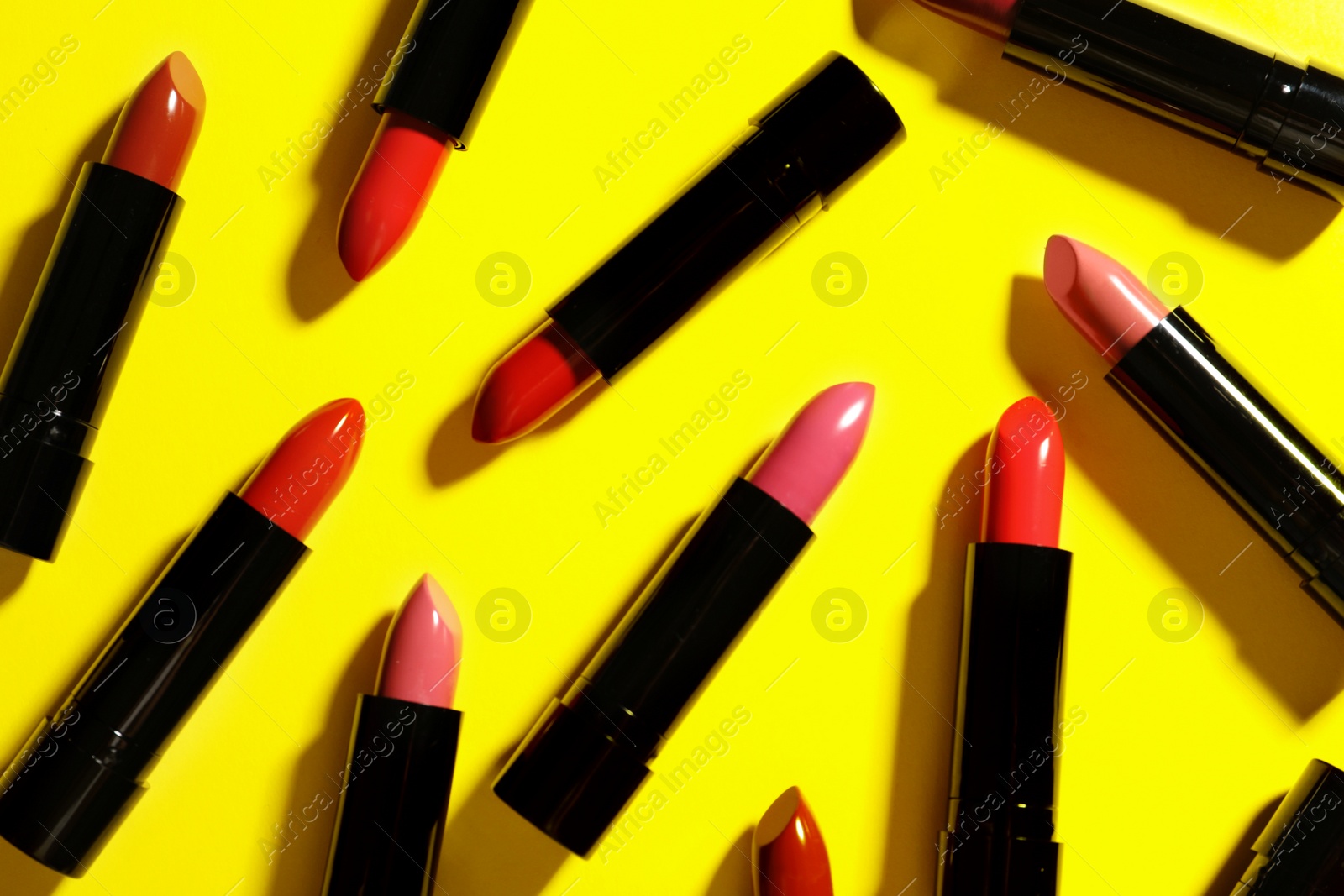 Photo of Flat lay composition with lipsticks on color background