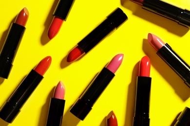 Flat lay composition with lipsticks on color background