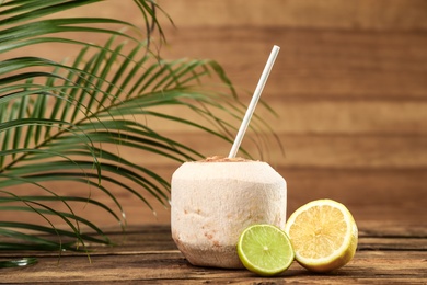 Photo of Open fresh coconut and citrus fruits on wooden table