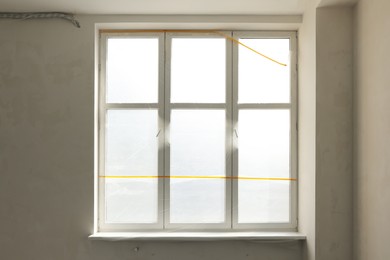 Window and sill covered by plastic film indoors