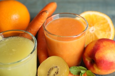 Photo of Glasses of delicious juices and fresh ingredients on table, closeup