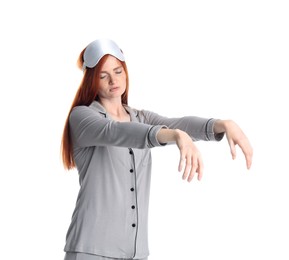 Photo of Young woman wearing pajamas and mask in sleepwalking state on white background