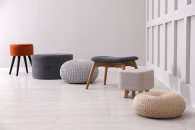 Photo of Different stylish poufs and ottomans in room