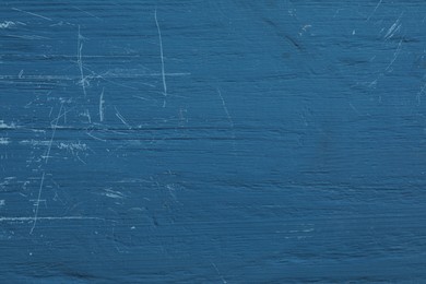 Photo of Old blue wooden surface with scratches as background, closeup