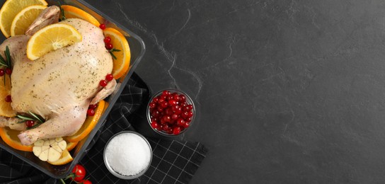 Photo of Flat lay composition with chicken, orange slices and ingredients on dark grey table. Space for text