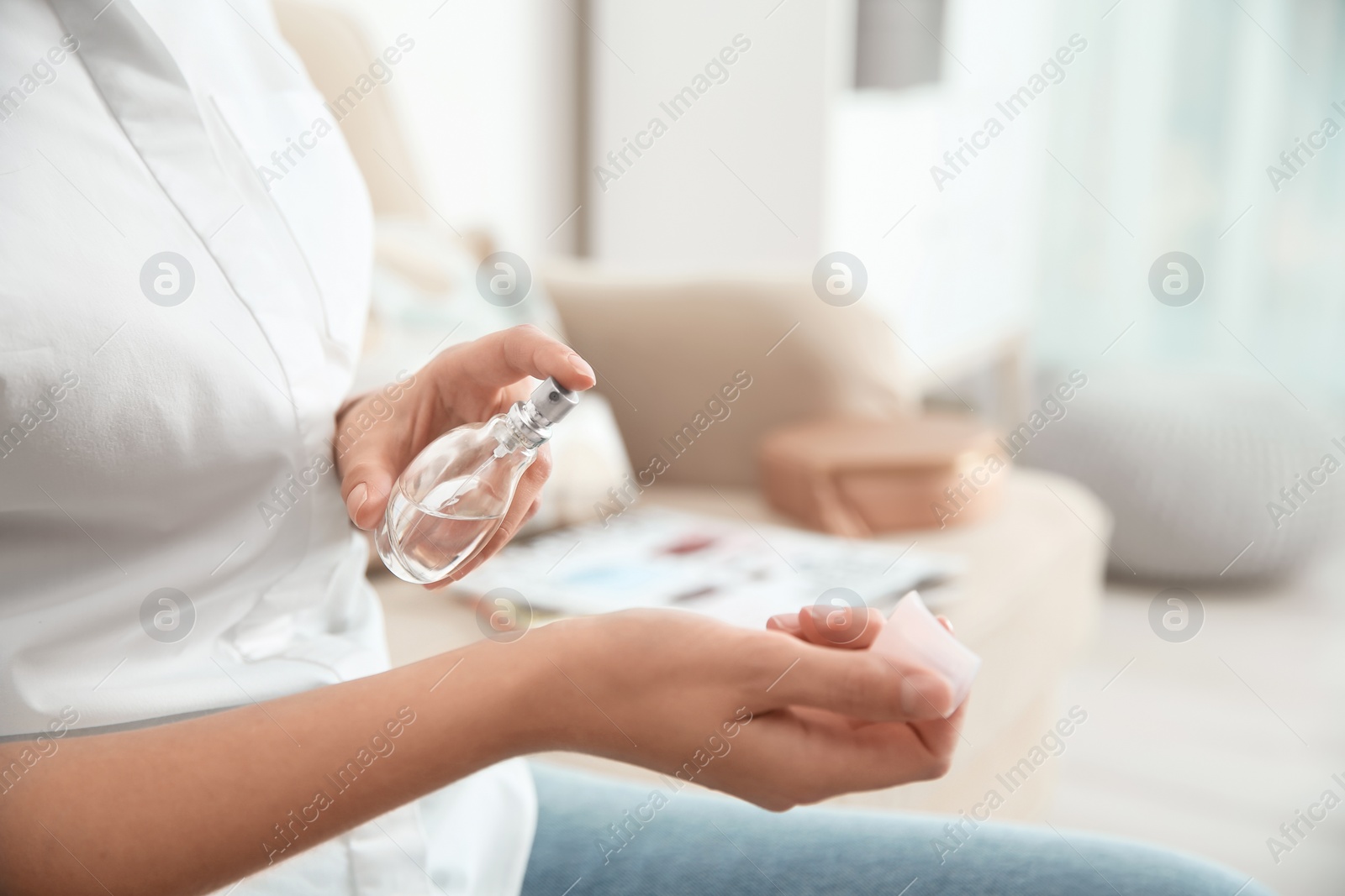 Photo of Young woman using perfume indoors, closeup. Space for text