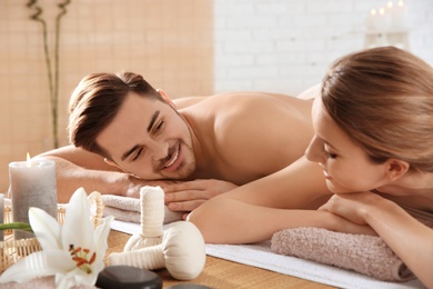 Young couple with spa essentials in wellness center