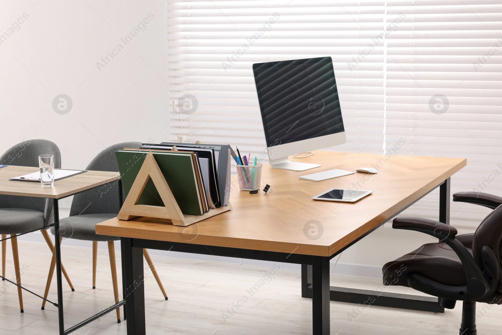 Photo of Director's office with large wooden table and comfortable armchairs. Interior design