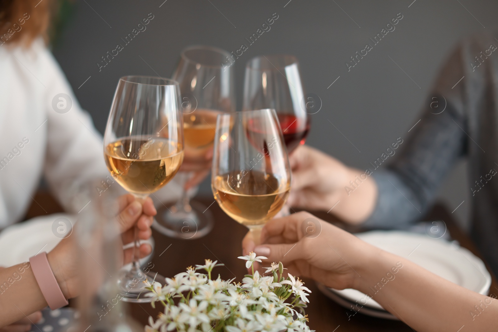 Photo of Young people with glasses of delicious wine at table