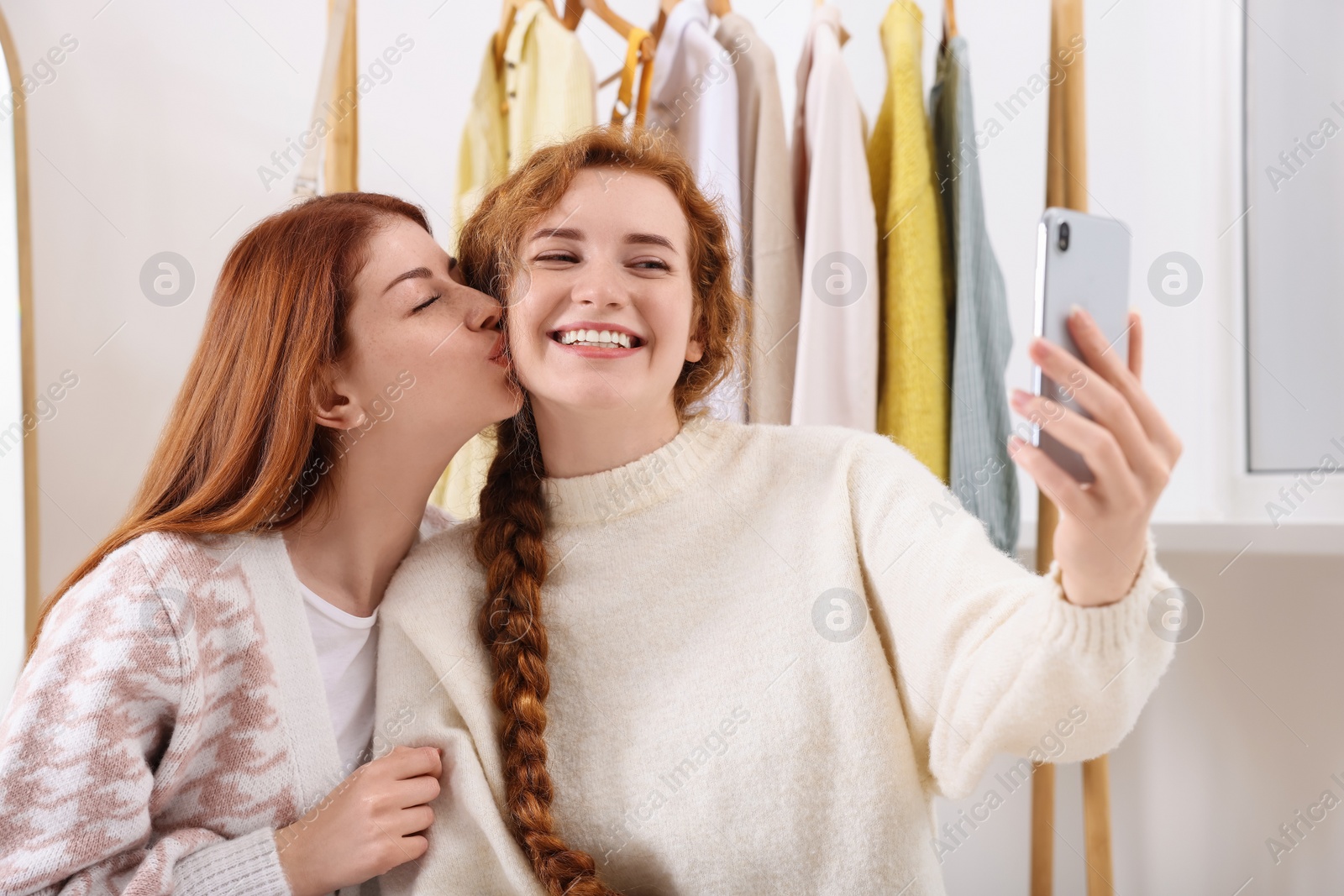 Photo of Beautiful young sisters taking selfie in dressing room